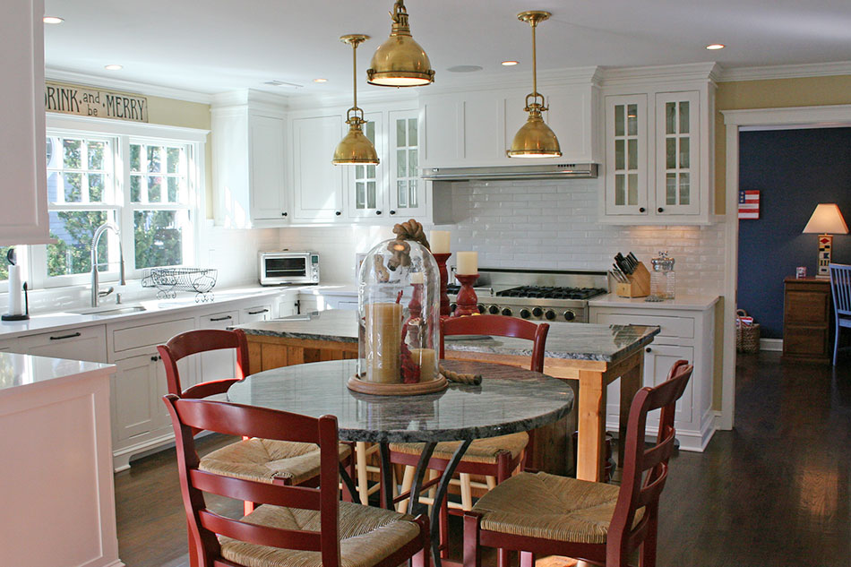On site, the kitchen cabinetry was handpainted with SNOWFALL WHITE OC-118. This beautiful soft white works well with the caesarstone and granite; it contrasts nicely with the darker wood floors. The touch of POWELL BUFF HC-35 on the walls plays off the brass nautical pendants, and it visually connects the kitchen with the living area.